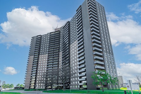 a tall apartment building with a blue sky in the background